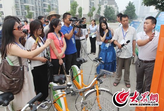 西線采訪團采訪了薛城區(qū)城市公共自行車服務系統(tǒng)，工作人員向記者們講解公共自行車的詳細情況。 記者 郭豪 攝。